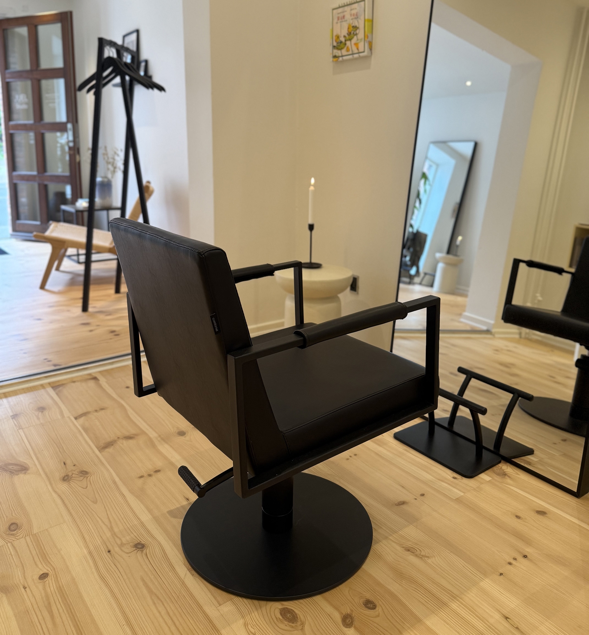 Moderne frisørstol foran spejl i lys salon hos frisør i Odense